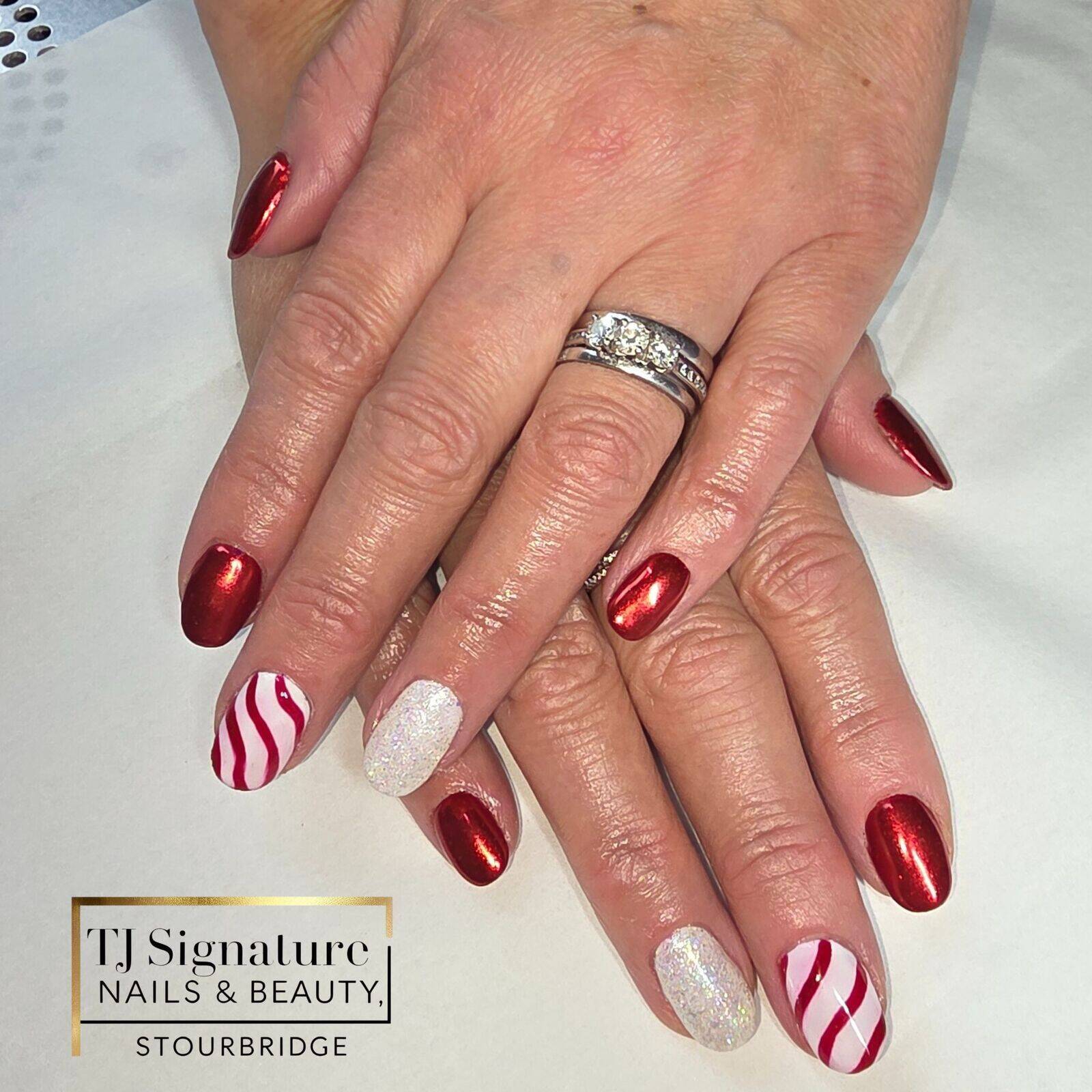 A festive Christmas set with red chrome, candy-cane stripes and snowy sparkle — one of the gorgeous seasonal designs created during a very busy week in the salon.