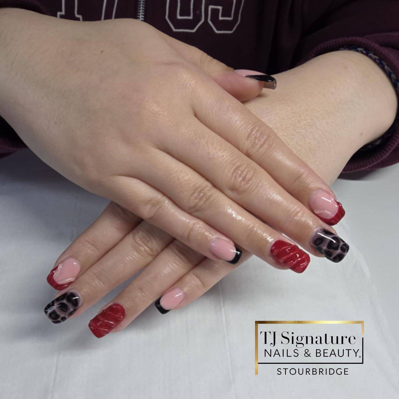 Red and black statement nails with animal print and glossy detail. A bold, confident mix of colours and textures for those who love a standout look.