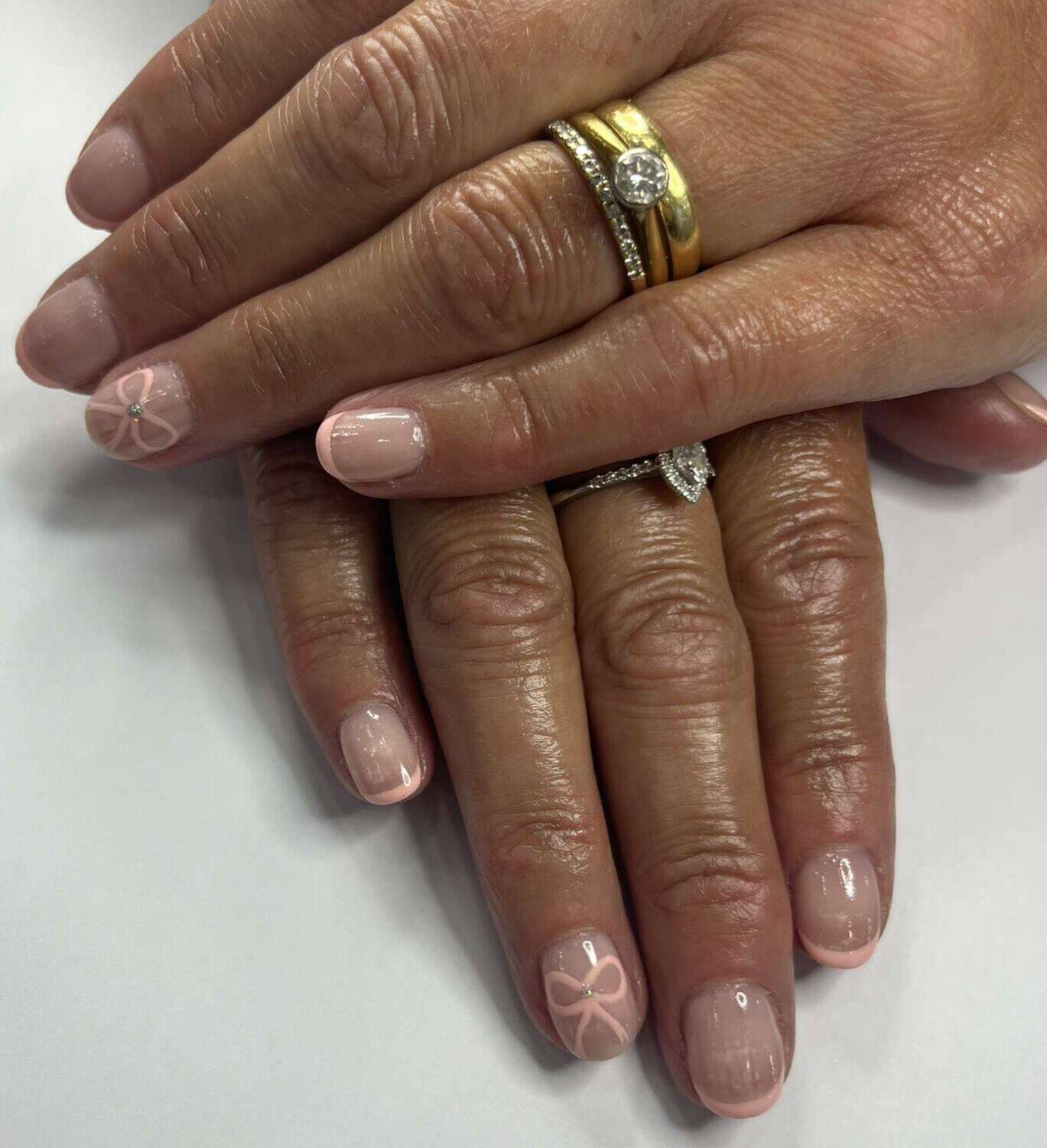 Elegant and understated, these soft pink nails feature delicate bow accents and a subtle glossy finish for a timeless, feminine look.