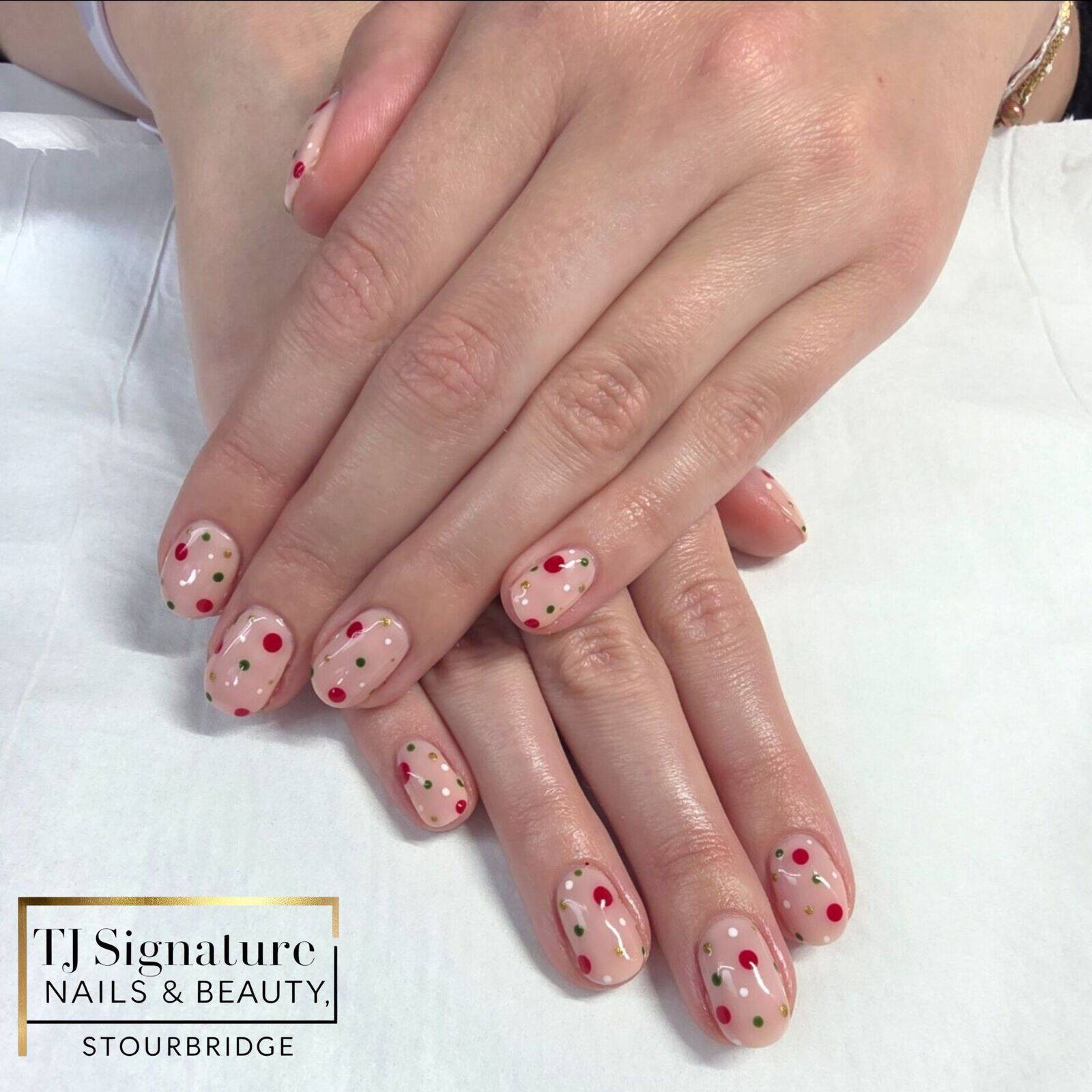 Soft nude nails finished with classic red and green dot detailing — a subtle festive design that’s clean, glossy and easy to wear. 