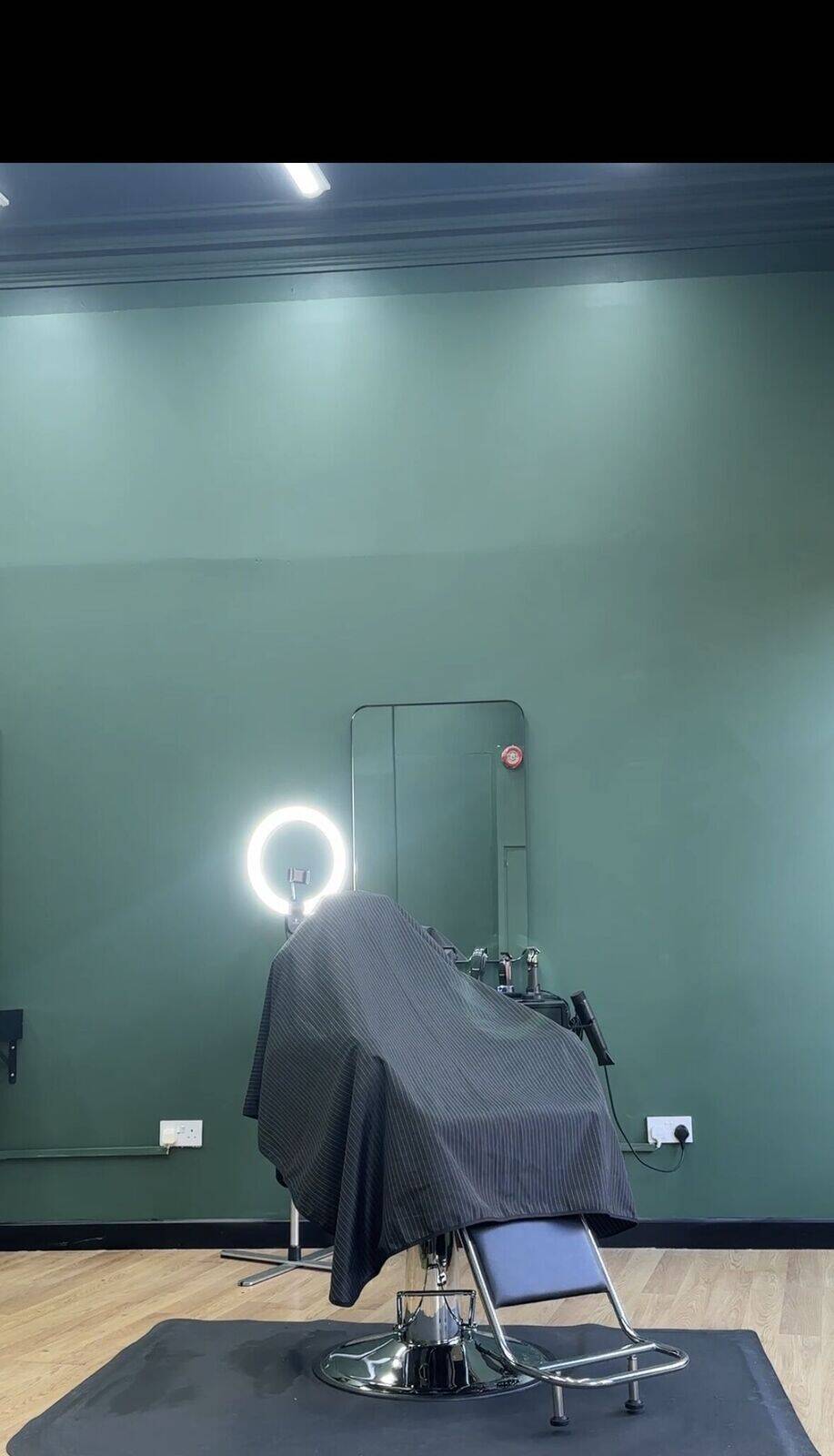 Modern barbershop interior in Musselburgh — RYZN Barbers & Grooming’s minimalist design with olive grove walls and professional barber stations.