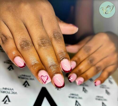 Semi-permanent mains rouge bordeaux avec un nail art en cœur ❤️ accompagné d’une color French. By Jade 🤍