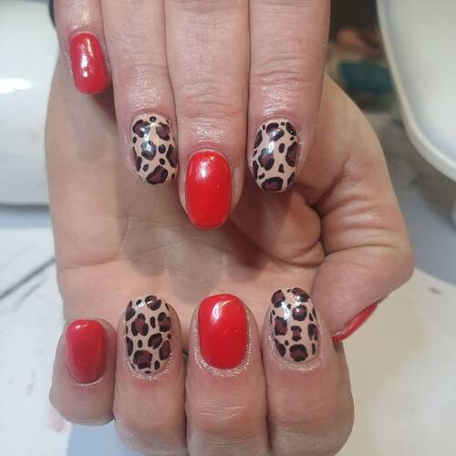 Red gel polish with leopard print nail art on natural nails