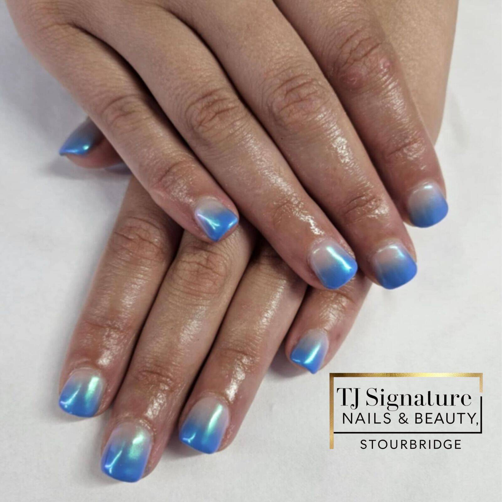 Shimmering blue ombré nails with a sleek, glossy finish.