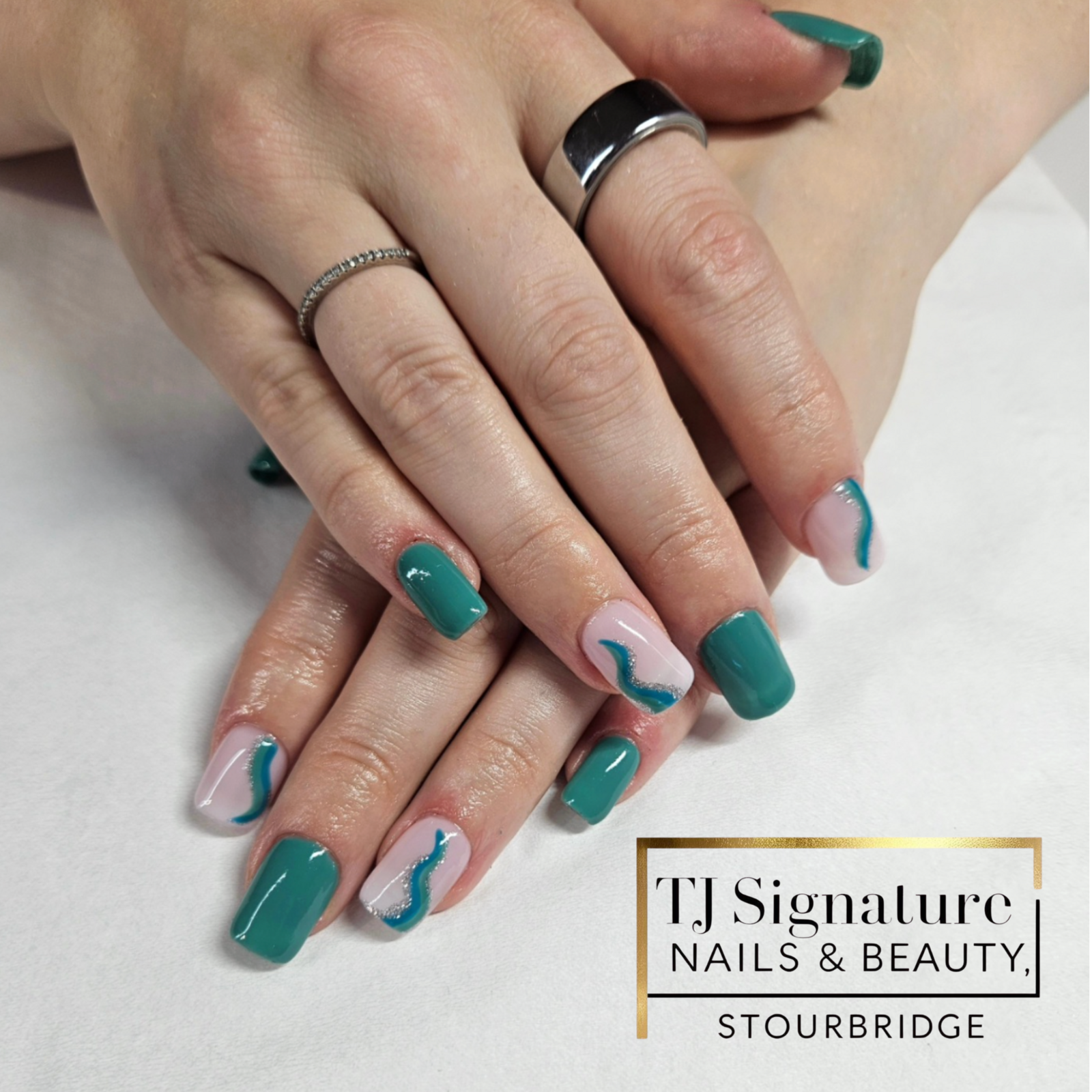 Fresh, fun and on-trend – teal nails with glitter swirl detail.