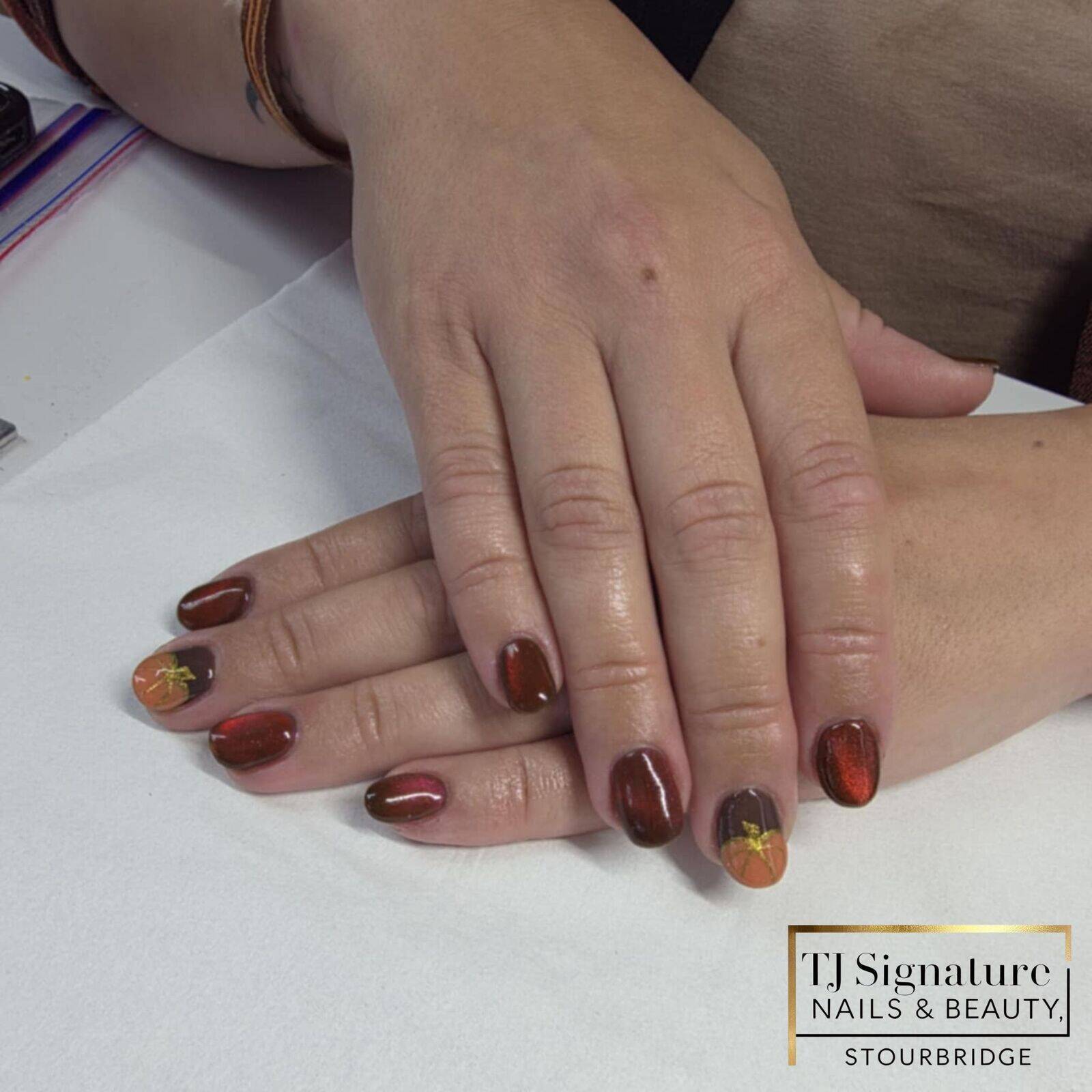 Warm autumn tones with a shimmering cat-eye finish and cute pumpkin details, created over a builder gel base for strength and natural growth.