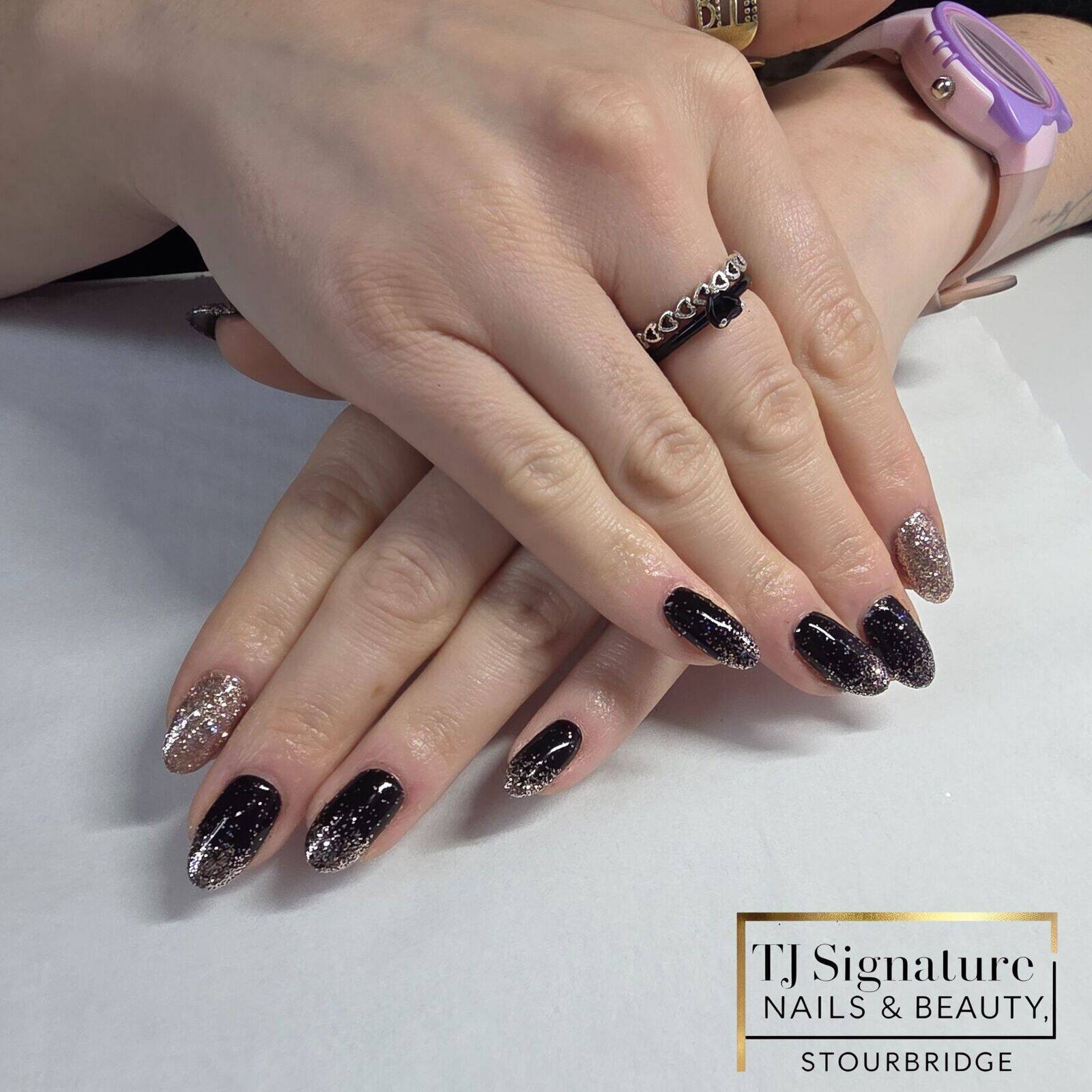 A sleek gel manicure featuring glossy jet-black tones with a soft champagne-glitter fade. Elegant, refined and perfect for a sophisticated festive look.