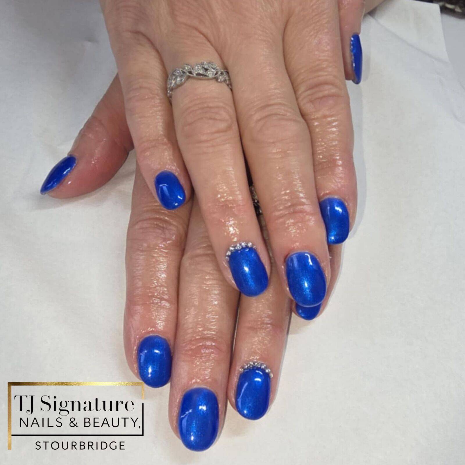 Builder gel manicure in a rich, glossy blue, finished with subtle diamanté details for that little bit of extra sparkle.