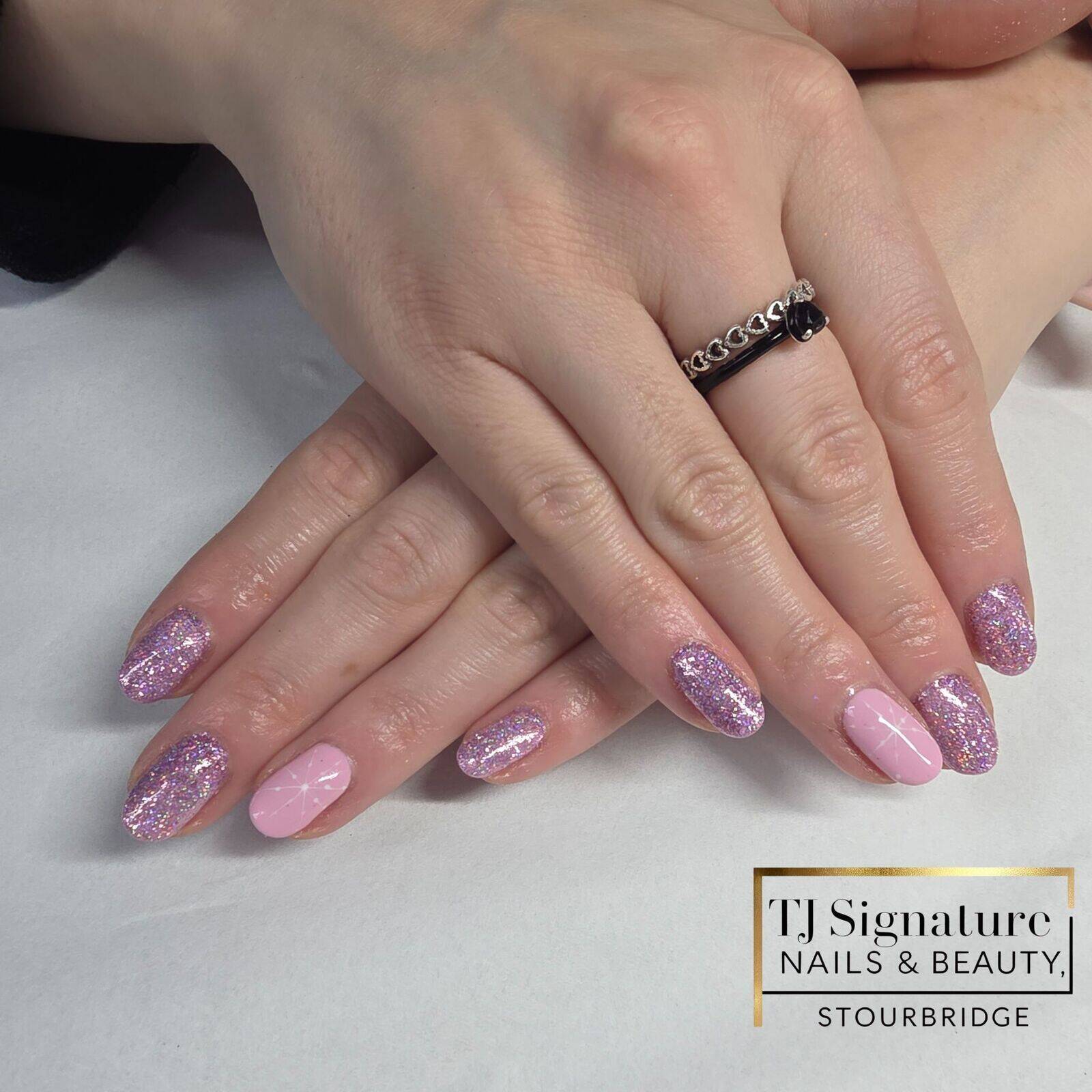 A soft winter look featuring pink glitter and a delicate white snowflake accent. This gel manicure has a smooth, glossy finish with a subtle festive touch — perfect for the season.