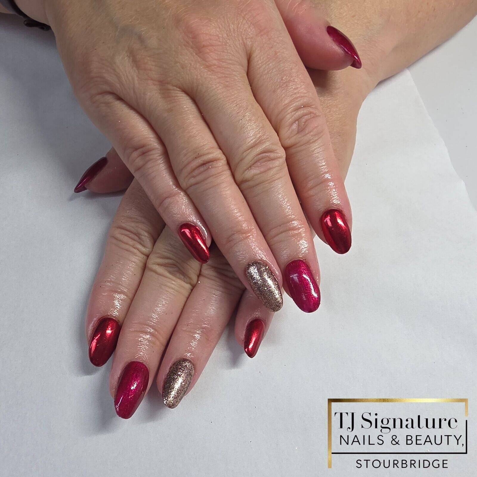 A festive gel manicure featuring rich ruby and metallic red tones, finished with a soft champagne-gold glitter accent. Glossy, elegant and perfect for a classic Christmas look.